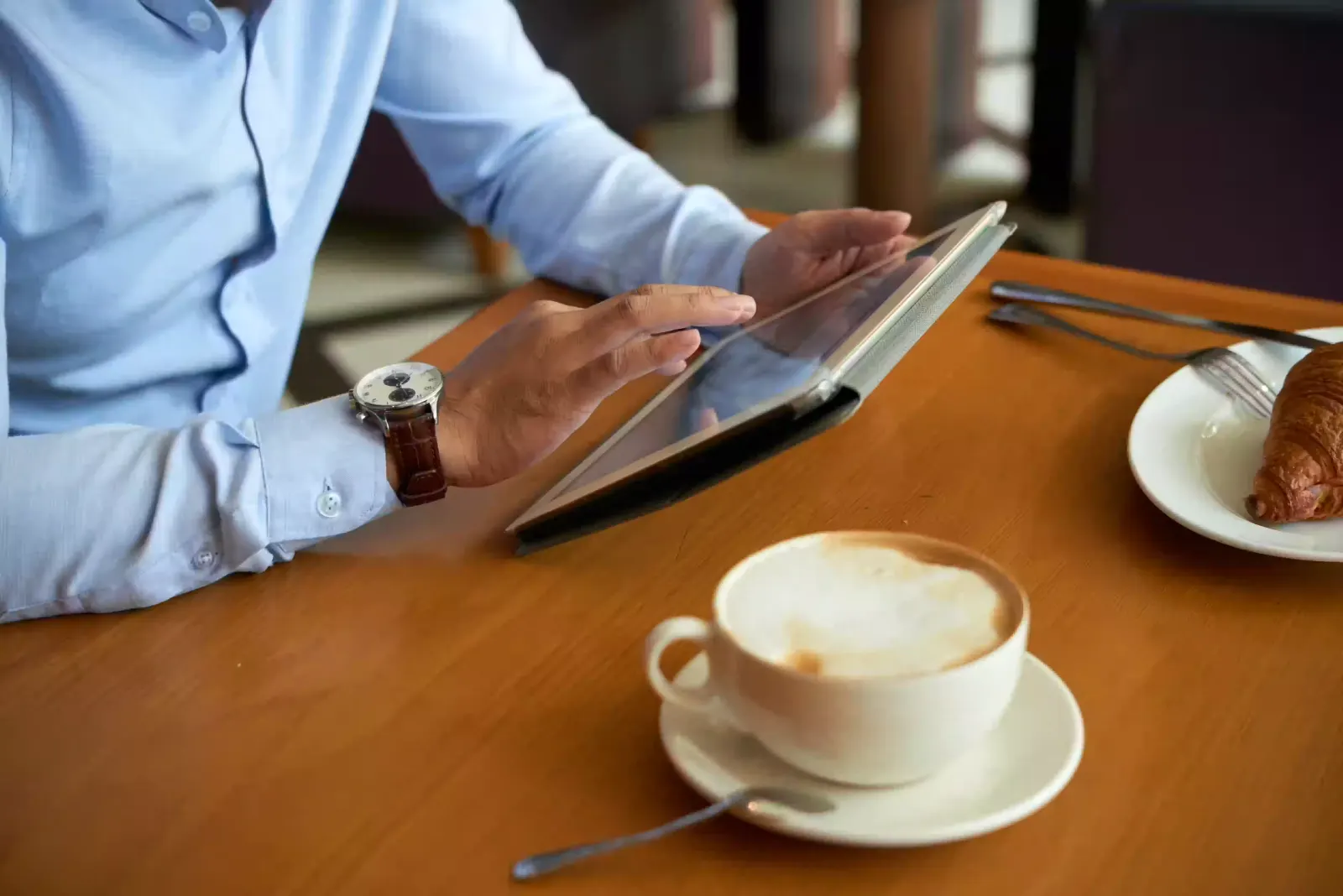 A phone showing a calm minimal business dashboard resting beside a coffee cup in early-morning light