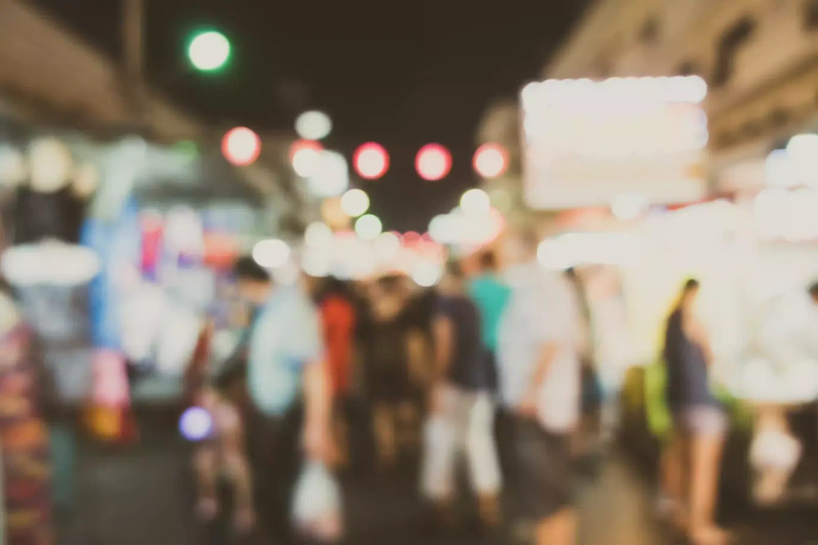 A busy Ghanaian market with one stall in sharp focus and a customer walking straight to it while the rest blur